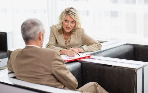 woman writing in front of a man
